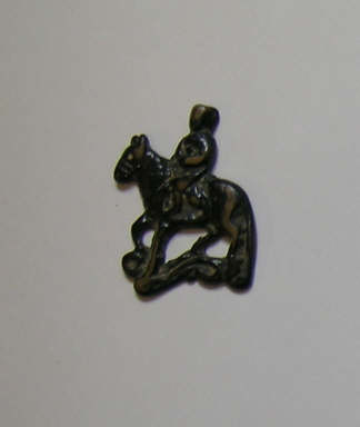 A garment plaque/amulet depicting a man riding a
