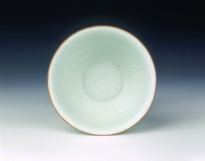 White glazed bowl with moulded design of dragons