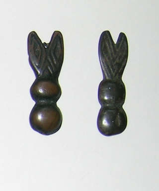 Two belt ornaments in the stylised form of winged