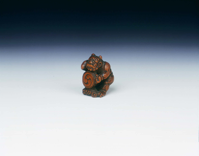 Wooden netsuke of Raiden beating a drum with