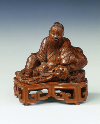 Bamboo shoot carving of a scholar leaning against
