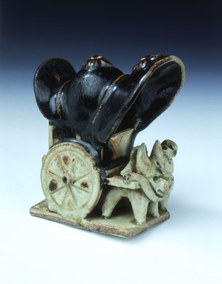 Ox-drawn covered wagon with lady passenger