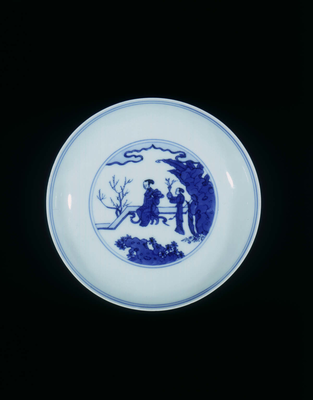 Blue and white saucer with figures on a garden