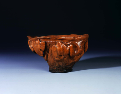 Large honey-coloured rhino horn cup with bat-like